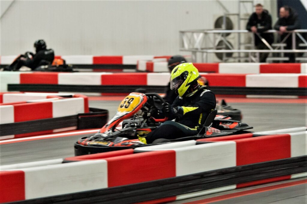 Junior i młodzież podczas jazdy gokartami elektrycznymi na technicznym torze w hali A1 Karting – nauka jazdy i świetna zabawa